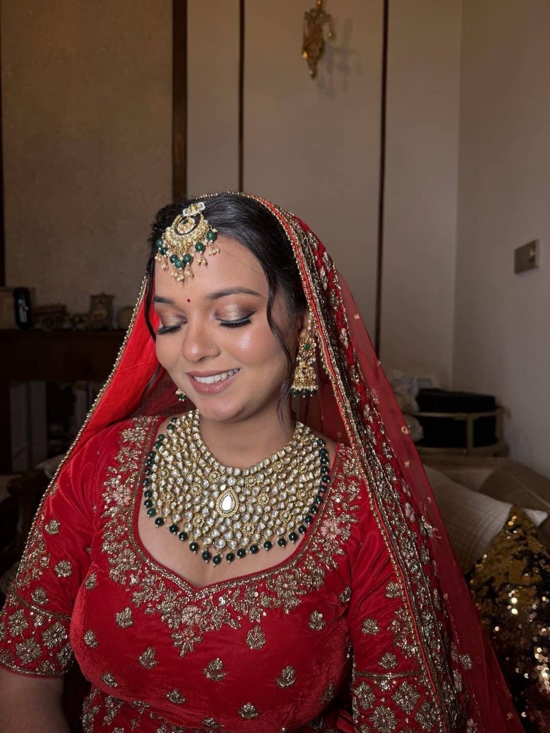 Bride in a red lehenga with kundan jewellery and soft glam bridal makeup by Priya Maleri, Tricity